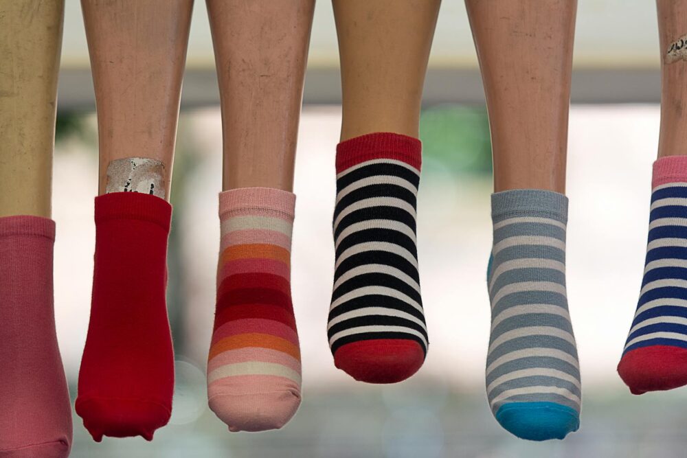A vibrant array of striped socks displayed on mannequin legs, showcasing fashion variety.