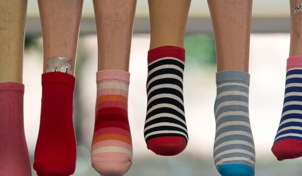 A vibrant array of striped socks displayed on mannequin legs, showcasing fashion variety.